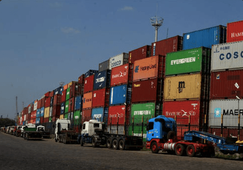 Caminhões enfileirados em frente a pilhas de containers no acesso ao Porto de Santos durante paralisação